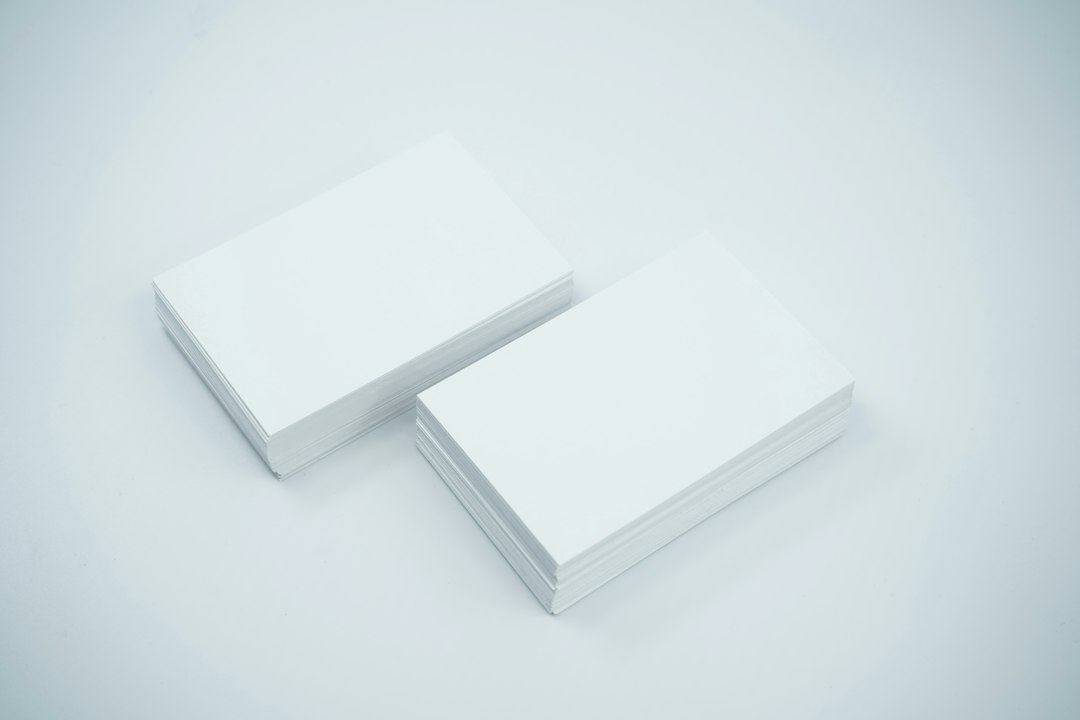 Two blank white business cards overlapping on a light grey background