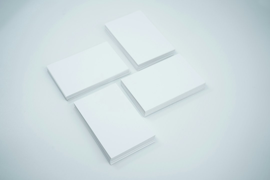 Several blank white business cards arranged on a light grey studio background
